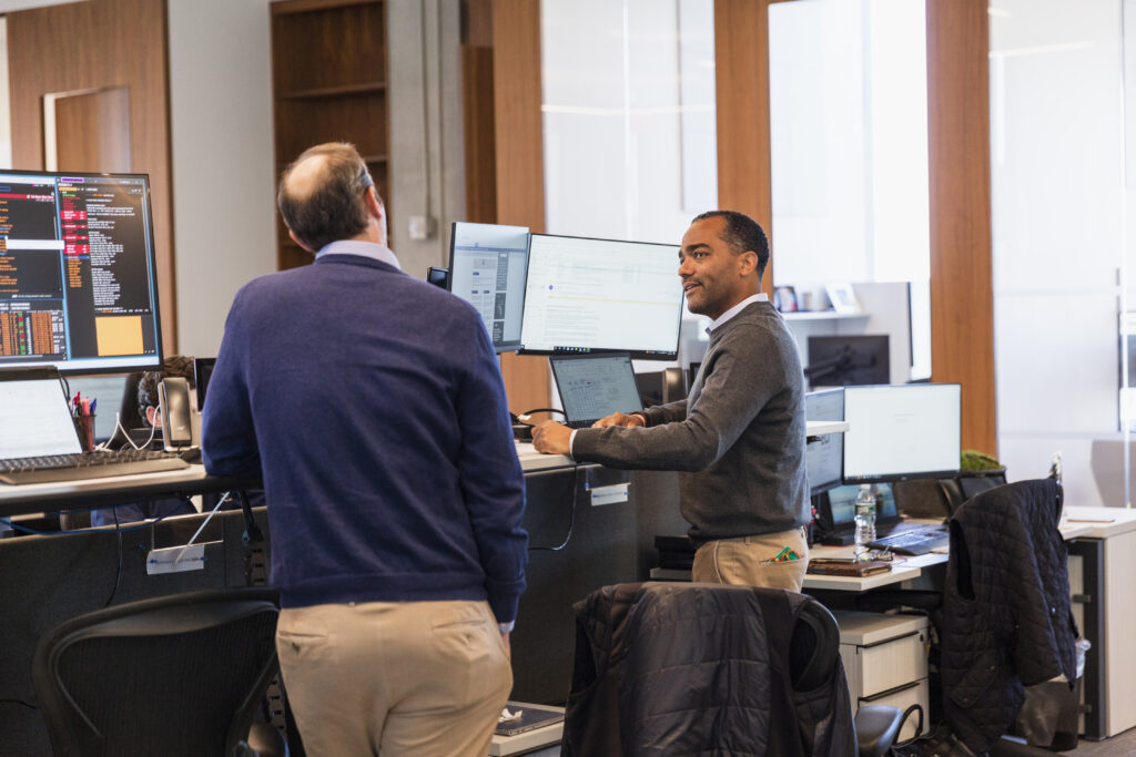 two people having a conversation at their desks